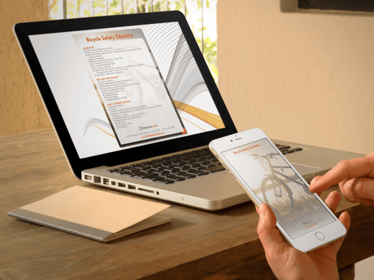 a person holding a phone and a laptop
