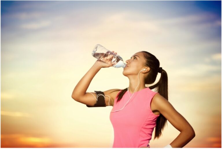 a woman drinking water from a bottle