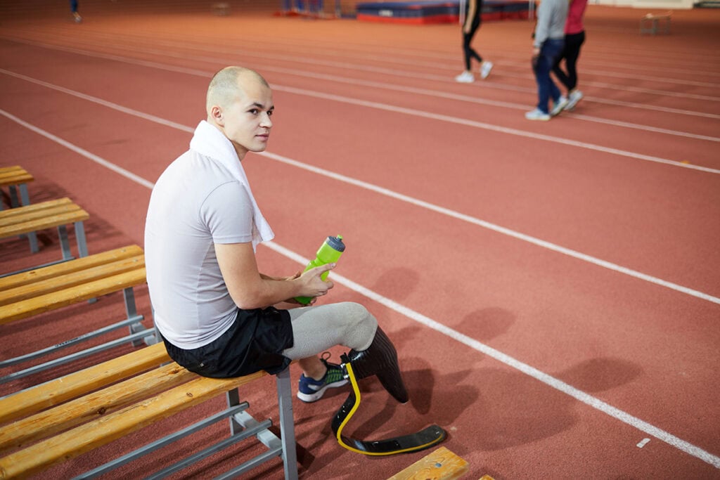 a man with prosthetic leg sitting on a bench
