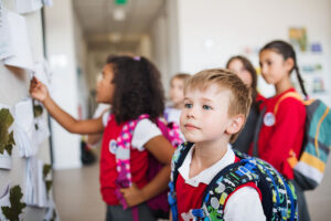a group of cheerful small school kids in corridor