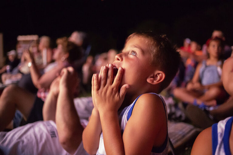 a boy with hands in front of his mouth