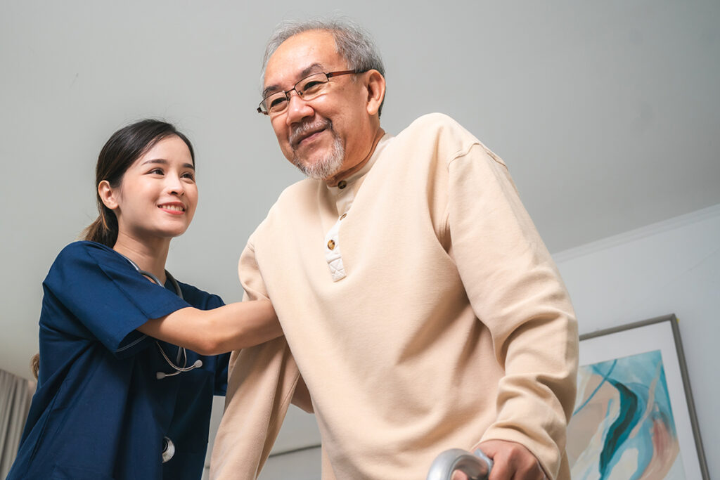 asian physiotherapist nursing home to support old man