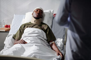 man with injury lying on bed in hospital