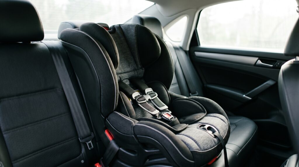 Child safety seat installed in the back seat of a car, illustrating car seat replacement after an accident in Texas