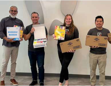 Four Snellings Law team members holding donated school supplies