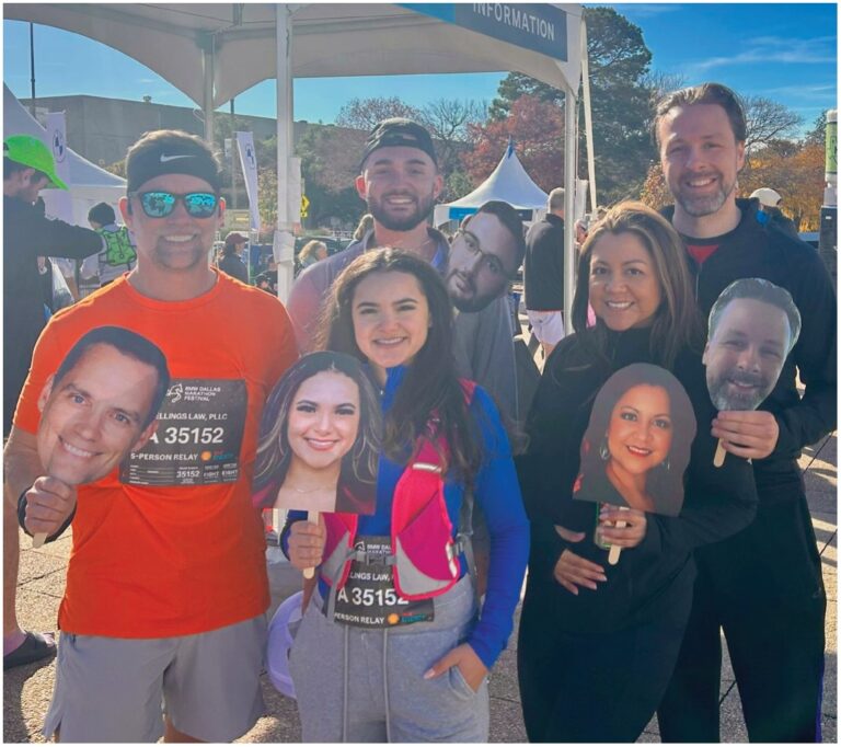 Snellings Law team members at a fun run holding cut-out photos of colleagues' faces