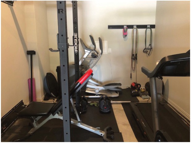 A home gym with a squat rack, an elliptical and a treadmill