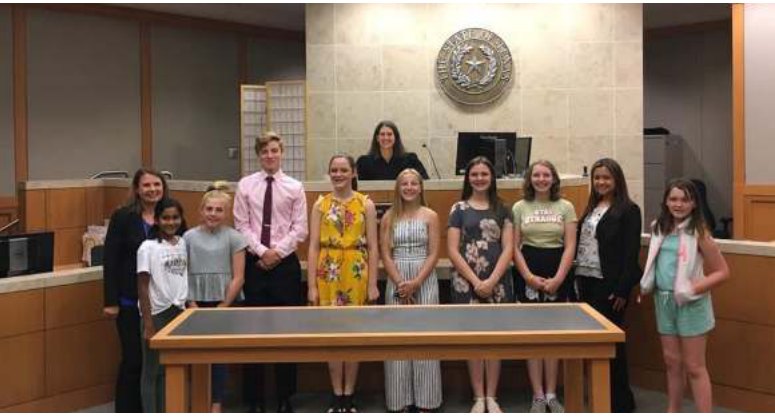 A group of mothers and children standing in a courtroom