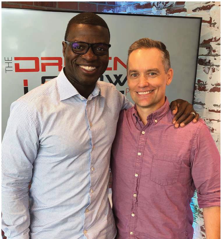 Two men smiling together on the set of The Driven Crowd podcast